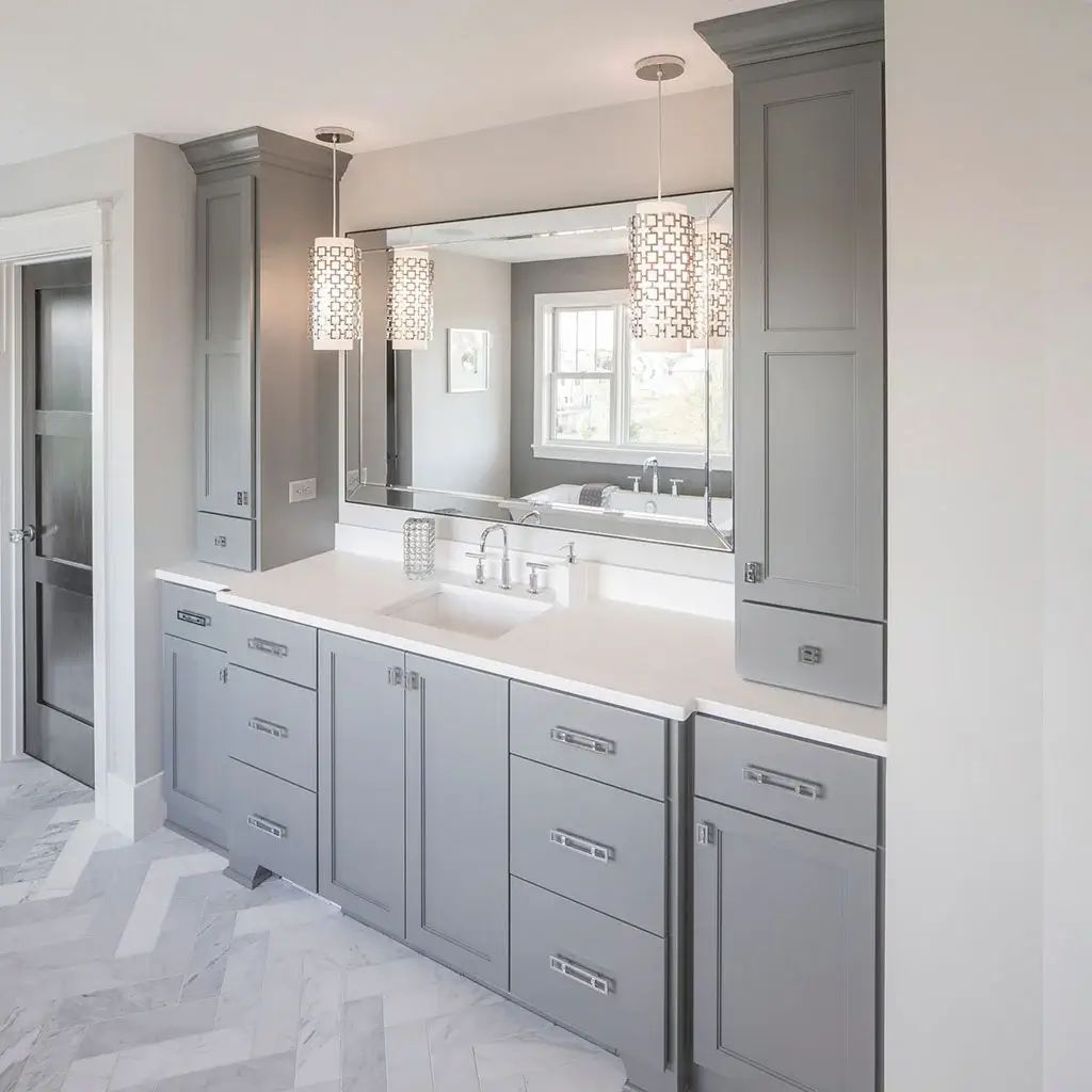 Bathroom with a gray double vanity, quartz top and herringbone tile floor
